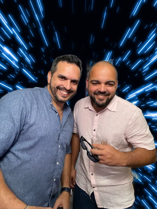 Birthday guests posing in front of a blue digital background