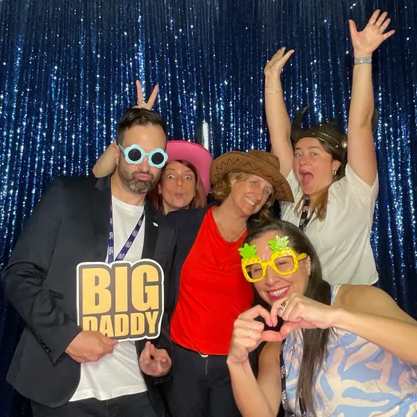 Coworkers posing with playful props at a Miami corporate photo booth