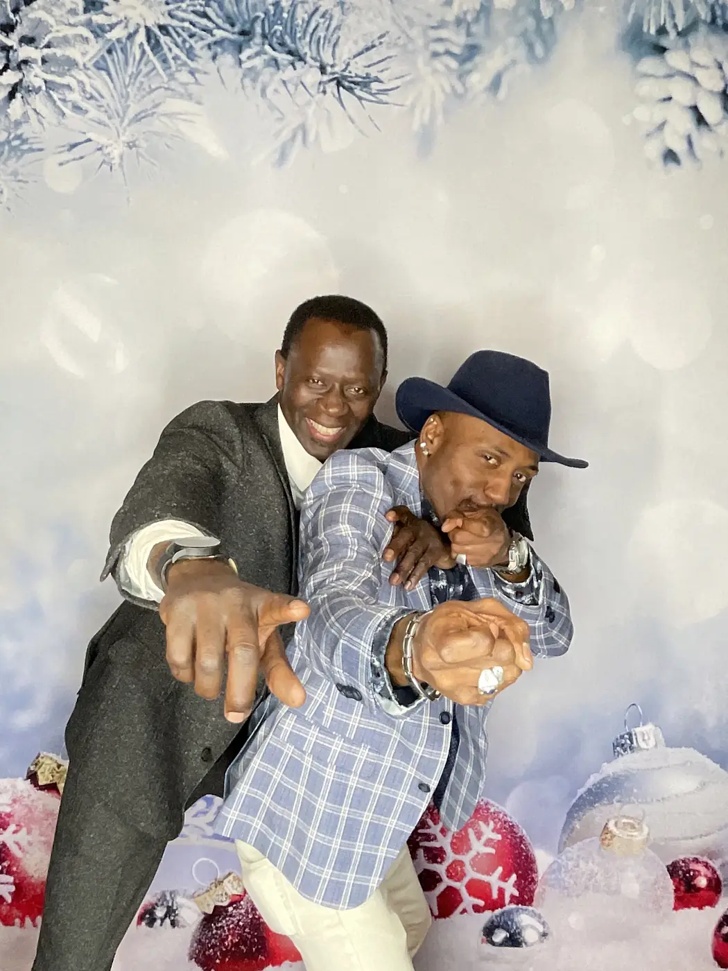 Two colleagues posing at the photo booth against a winter backdrop at a Miami holiday party