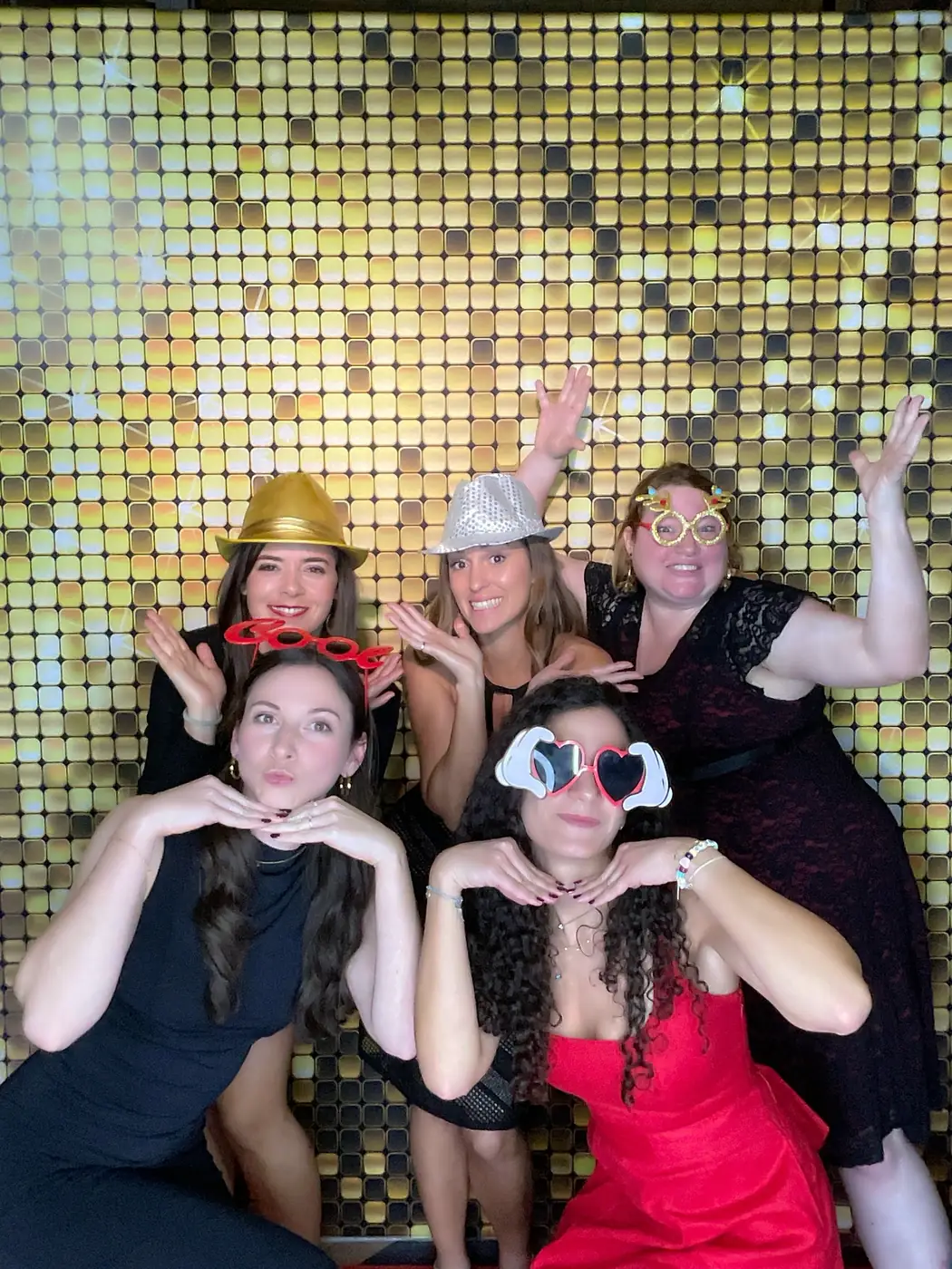 Colleagues against a gold sequin backdrop at a Miami corporate holiday party
