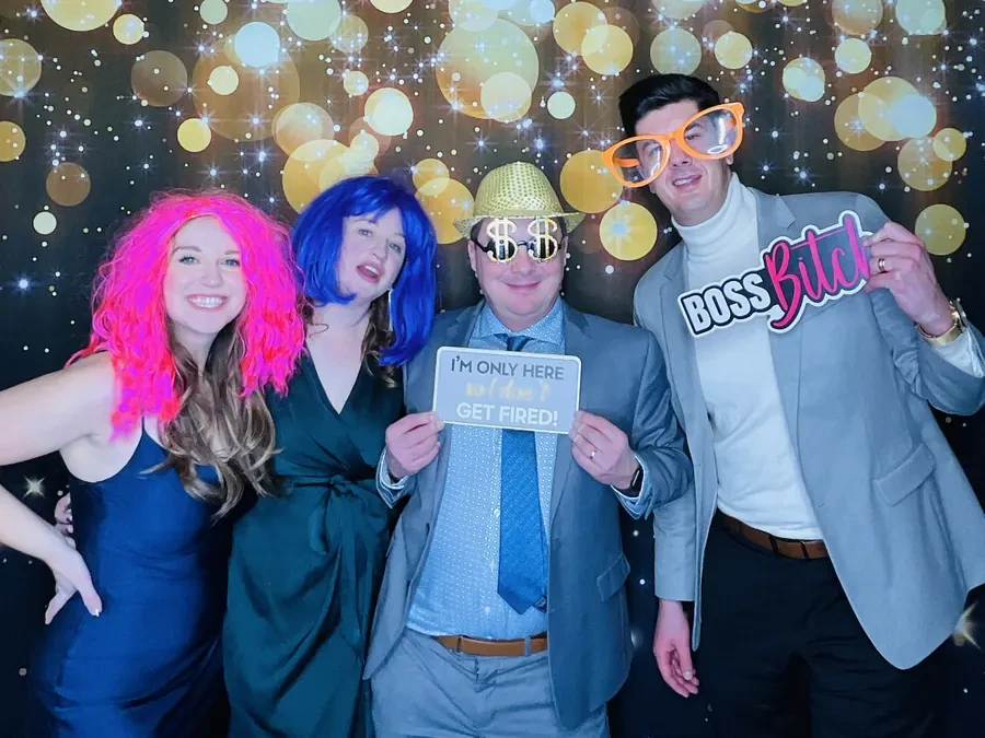 Colleagues in props at the photo booth during a Miami holiday party