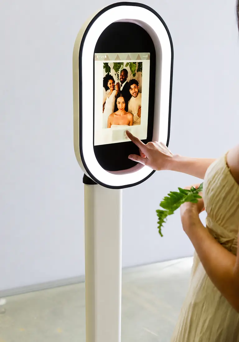 The drop-off photo booth on its stand, operated by a guest with no attendant present