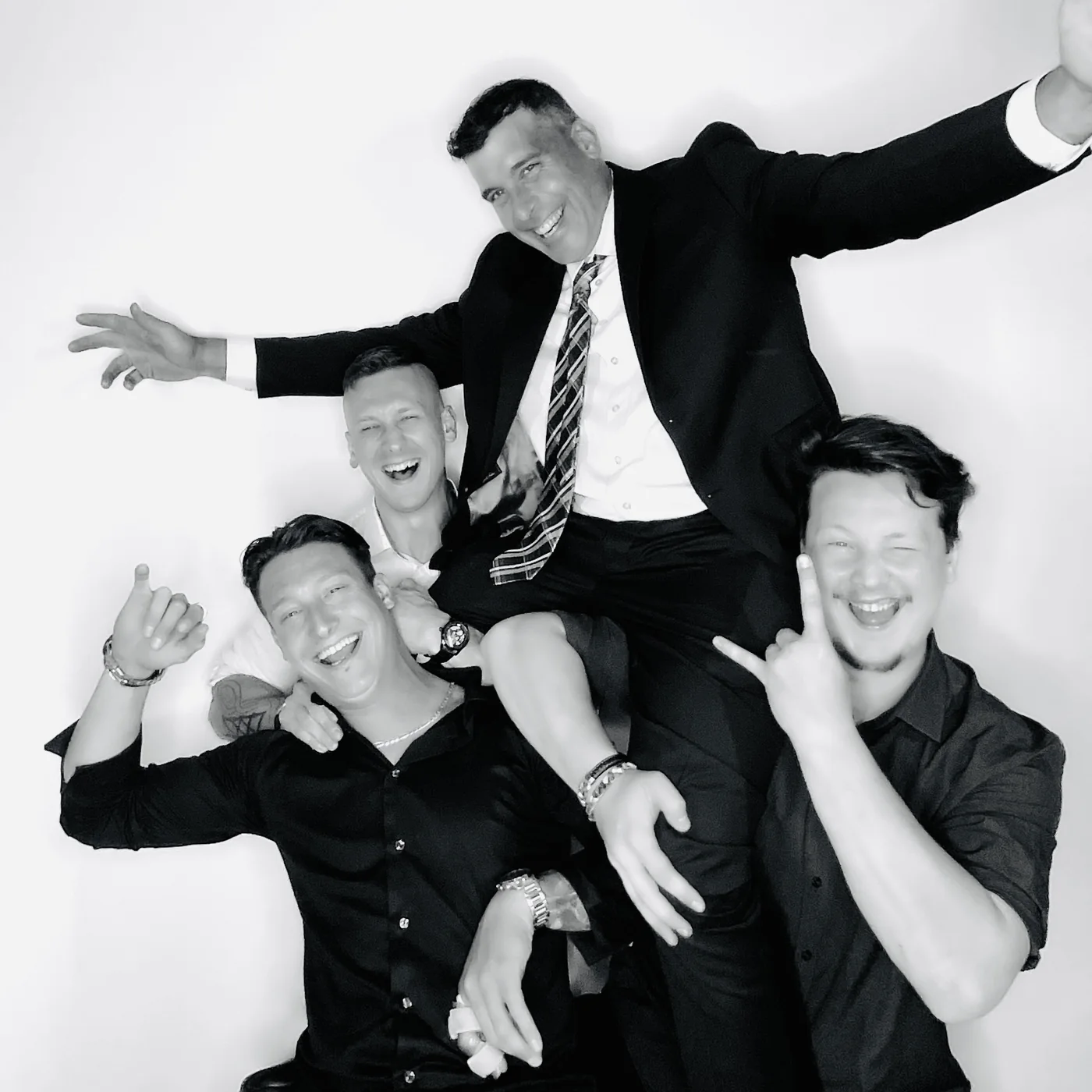 Black and white glam portrait of groomsmen lifting a guest at a Miami wedding