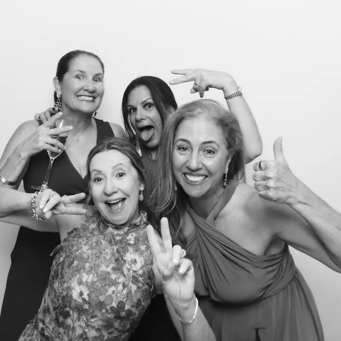 Four guests posing for a black-and-white Glam Booth portrait