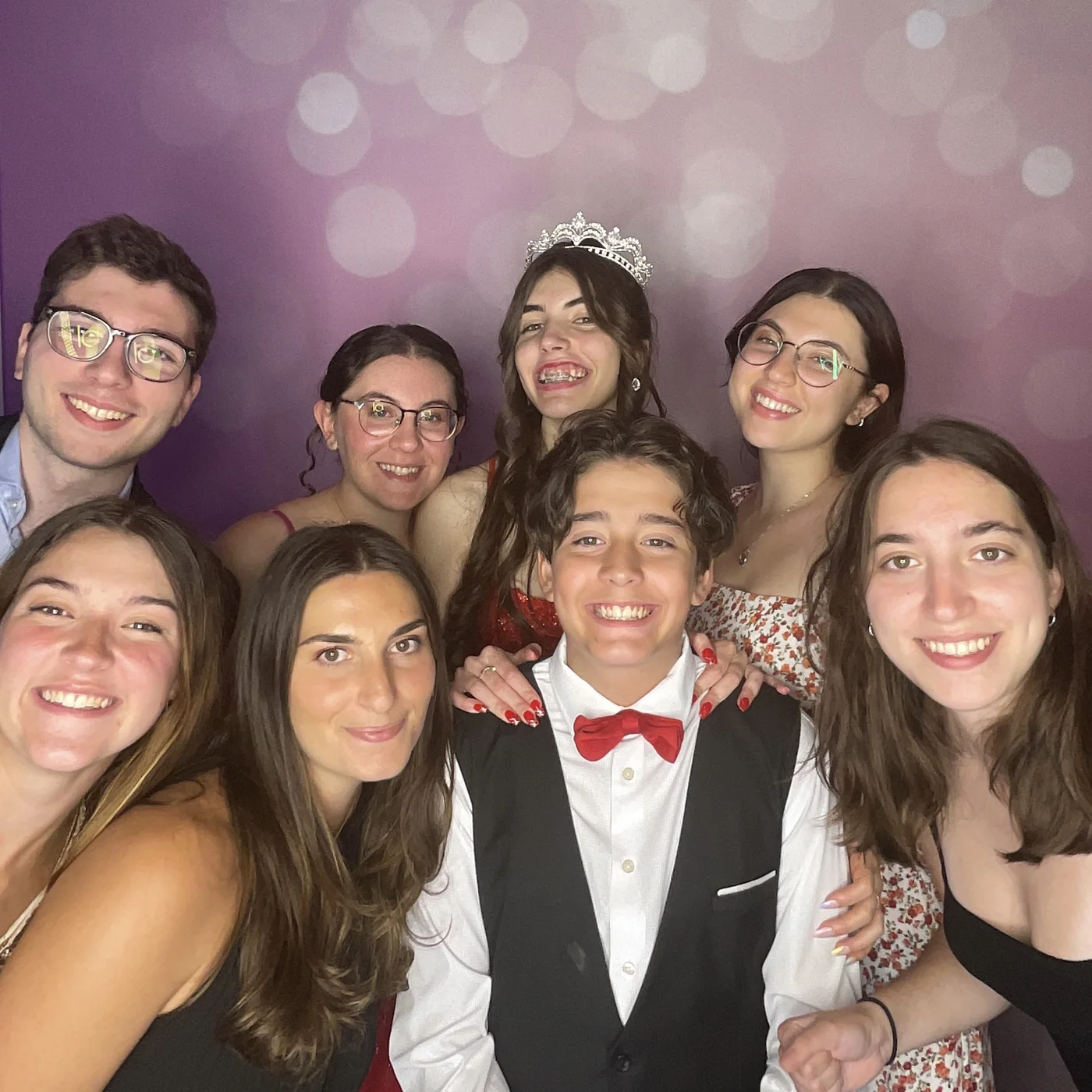 Quinceañera wearing her tiara with members of her court at the photo booth