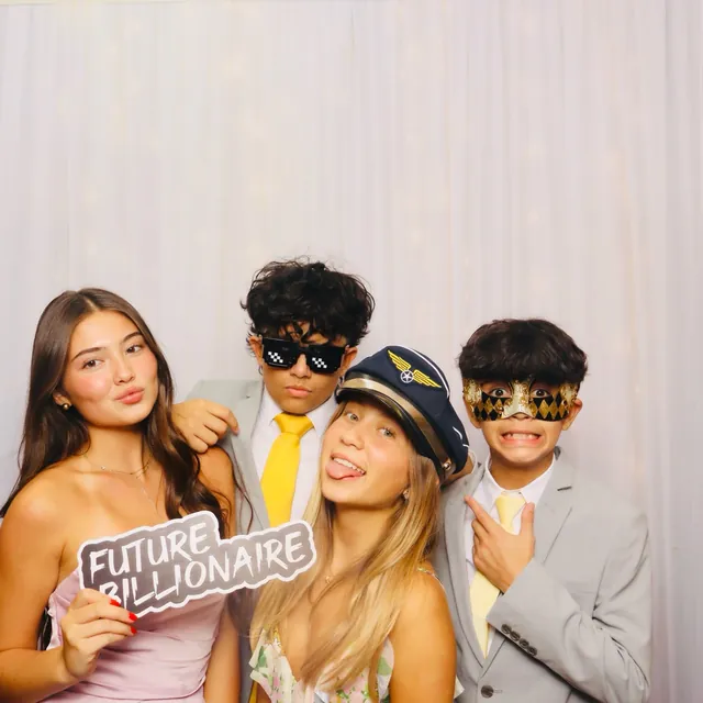 Quinceañera guests posing with themed photo booth props