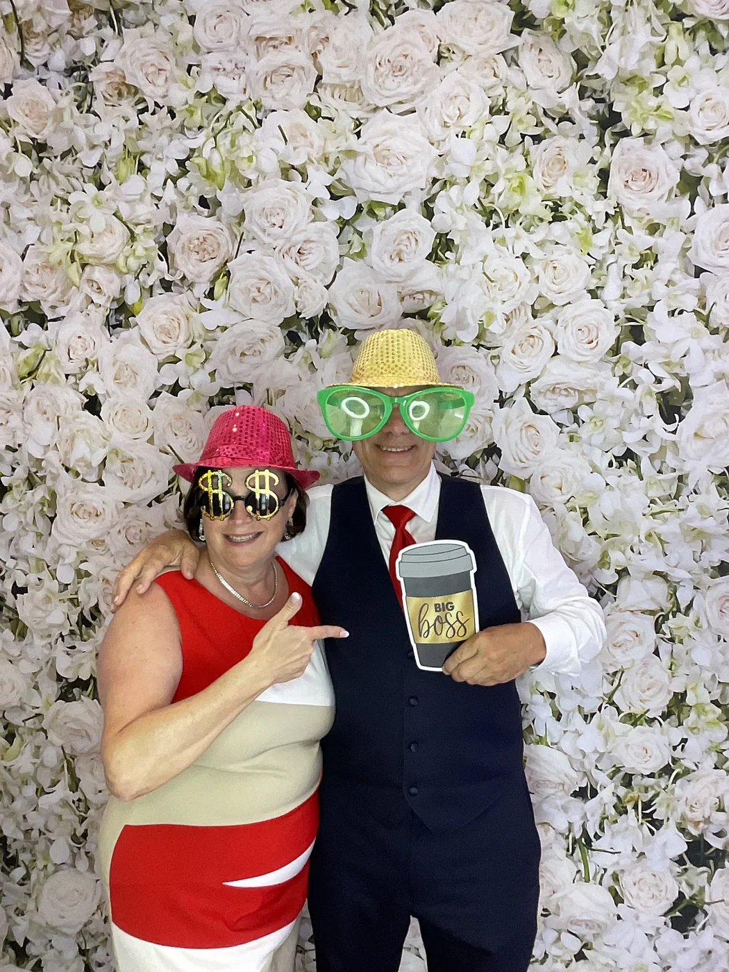 A couple with novelty props at the photo booth at a wedding in Aventura