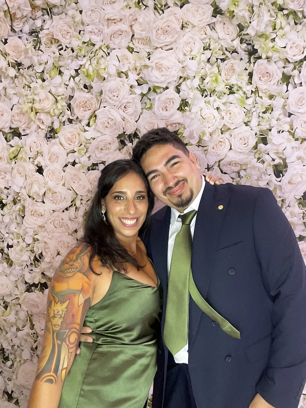 A couple at the photo booth with a floral backdrop at a wedding in Aventura