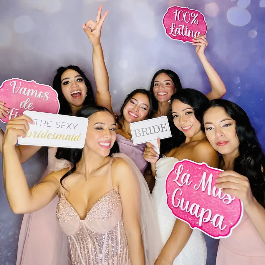 Bridal party holding props and signs at the Eleganza photo booth in Miami