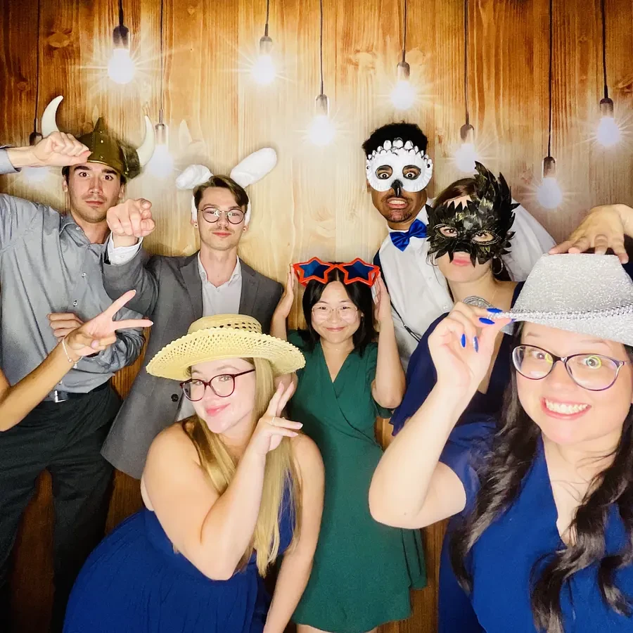 Guests at the photo booth against a gold bokeh backdrop at a Miami wedding
